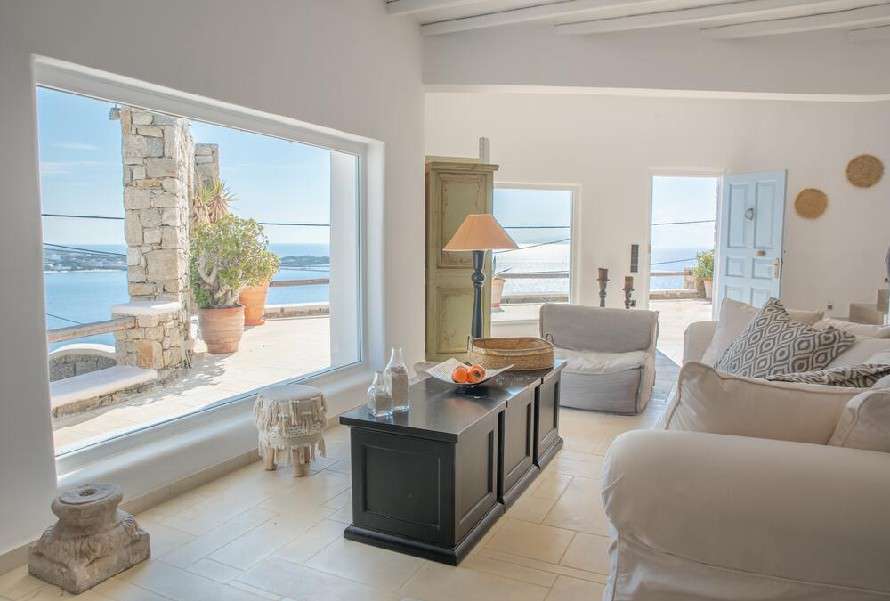 view of the crystal blue sea from the living room with large windows providing daylight