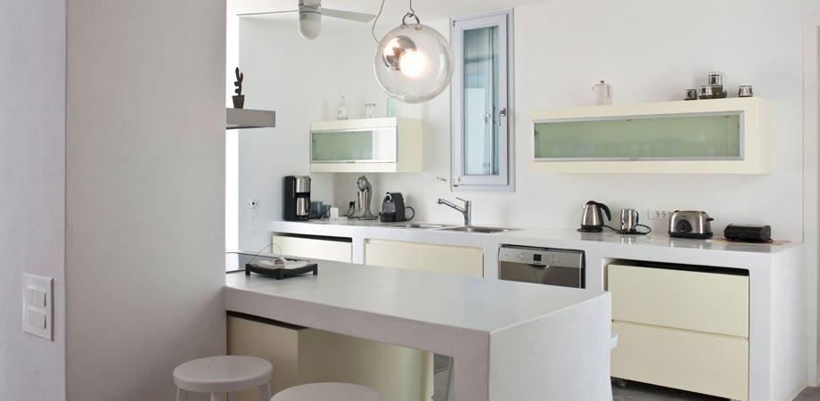 fully equipped applied layout kitchen with white table elevated bar stool chairs