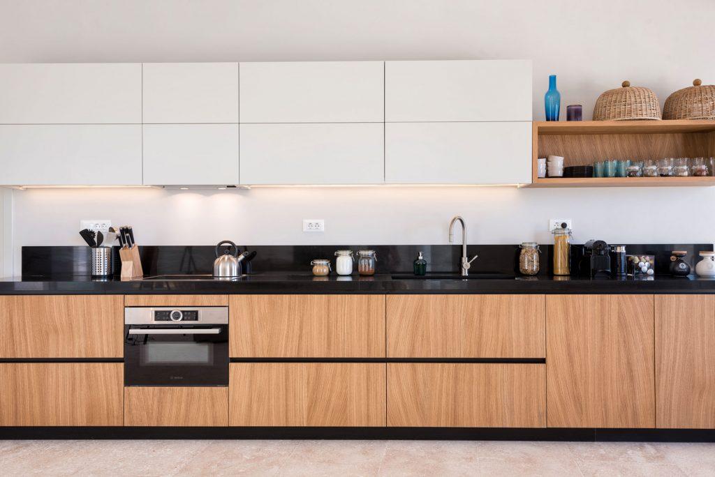 fully equipped applied layout kitchen with wooden elements and integrated oven
