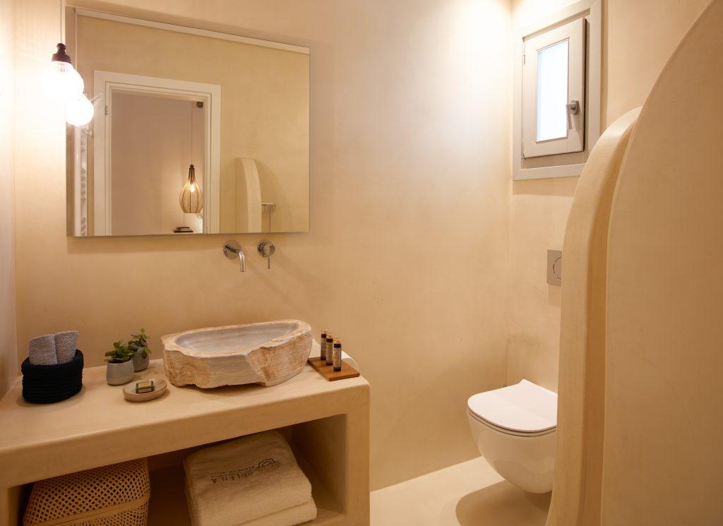 beige wall bathroom with huge mirror and toilet