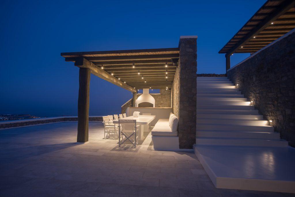 lighted stone walls and a white dining table, an ideal place for an outdoor dinner with friends