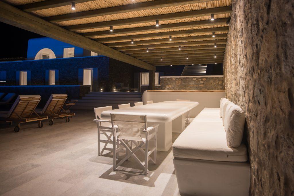 lighted stone walls and a white dining table, an ideal place for an outdoor dinner with friends