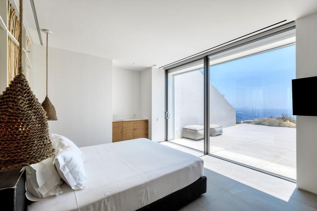 snug and cozy bedroom containing king size bed wall mount TV facing window wall sea view