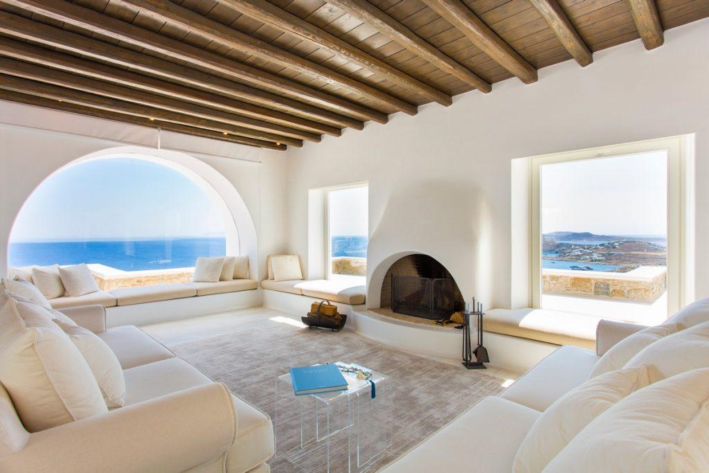 luxurious living room overlooking the sea of Mykonos and a white fireplace that adds atmosphere
