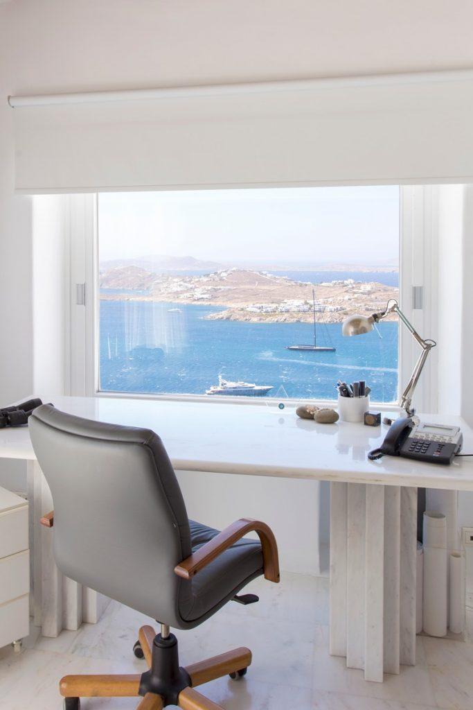 desk with comfortable chair and soothing sea view