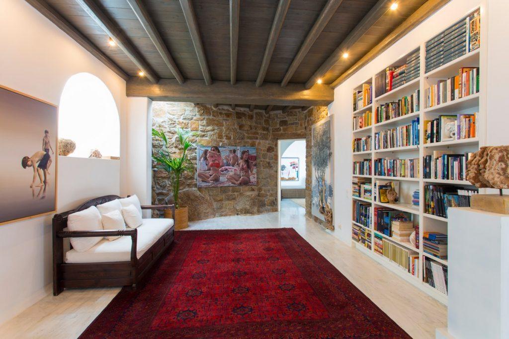 white walls of room with bright red details and a large bookshelf ideal for enjoying peace and good reading