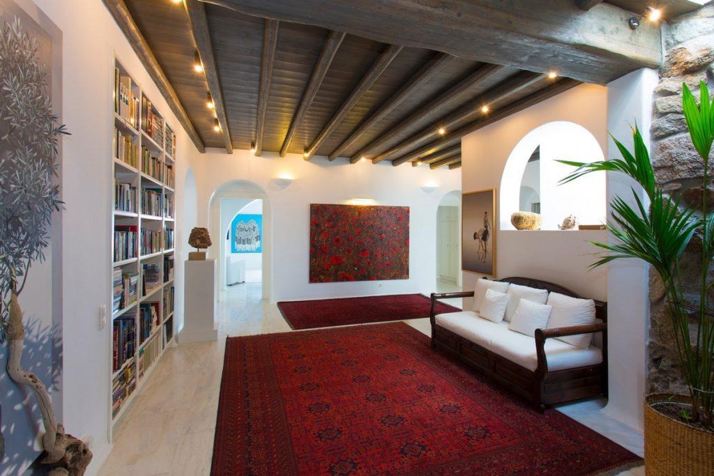 white walls of room with bright red details and a large bookshelf ideal for enjoying peace and good reading