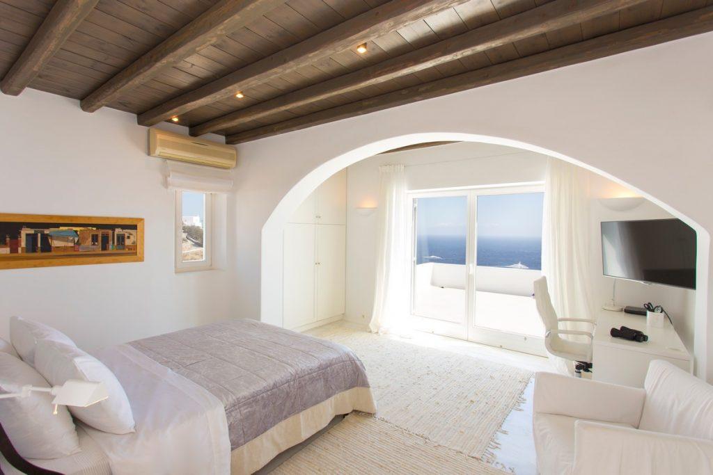 bedroom with a view of the calm sea and a comfortable bed