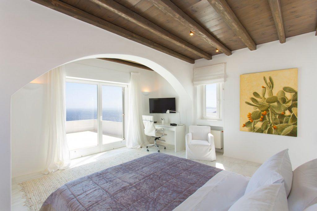 bedroom with a beautiful view of the glistening sea and a comfortable bed ideal for relaxing