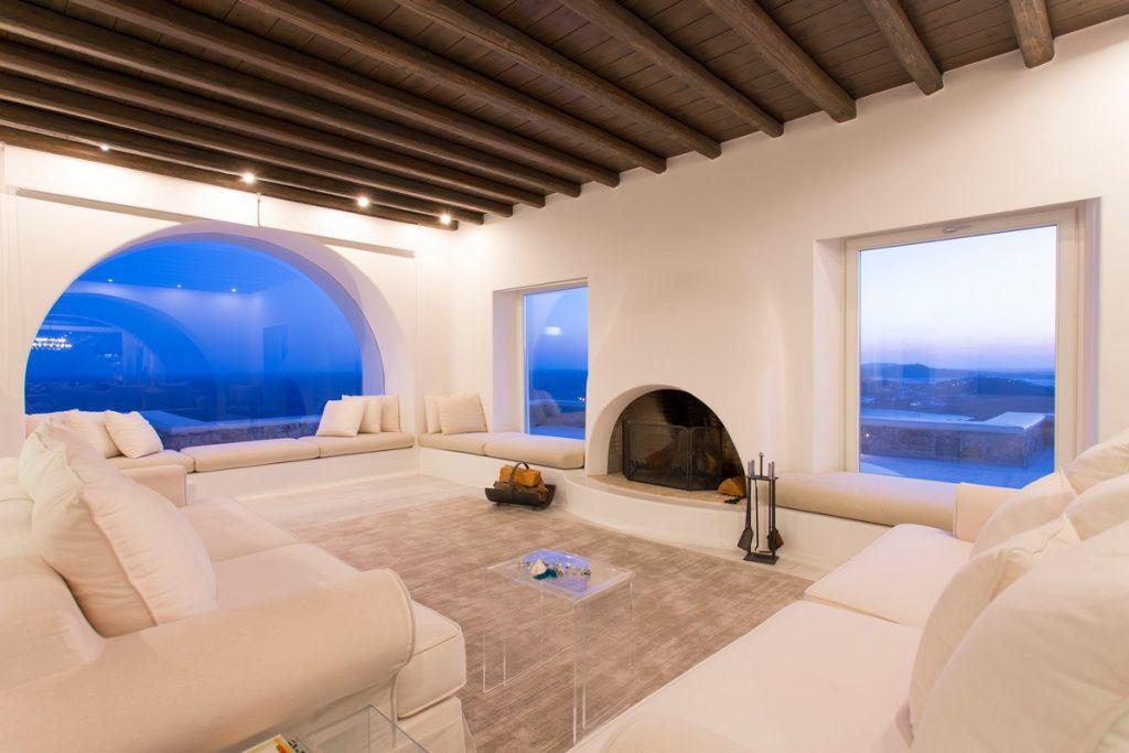 luxurious living room overlooking the city of Mykonos and a white fireplace that adds atmosphere