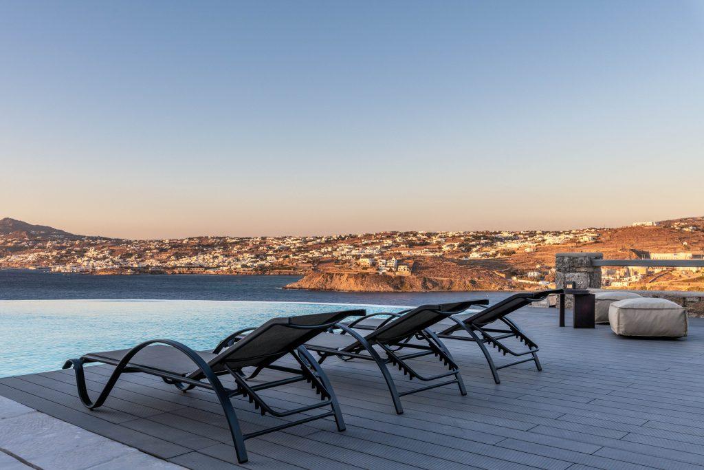 view of the sunset over the city of Mykonos from the pool