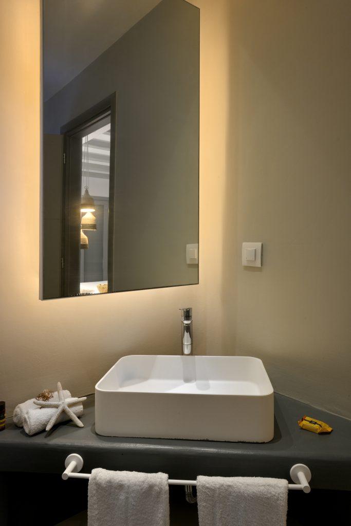 illuminated mirror with a ceramic sink decorated with a white star in the corner