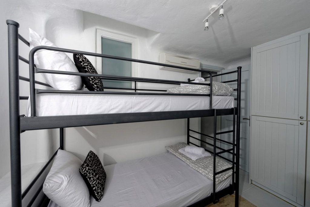 room with comfortable bunk beds and soft black and white pillows