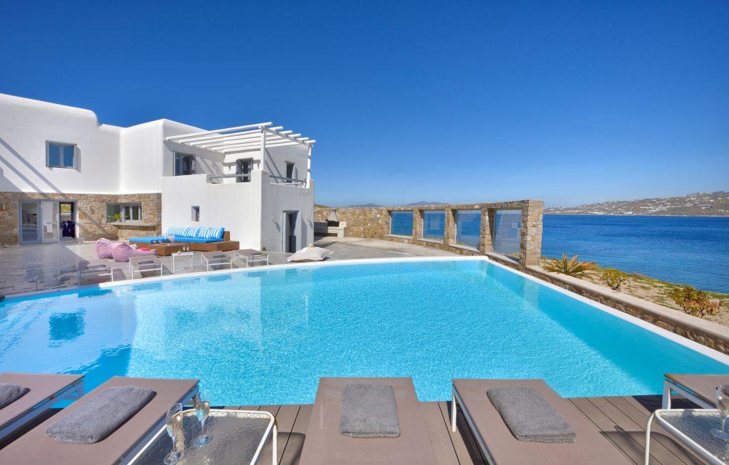 spacious courtyard of the villa with pool and views of the crystal blue sea