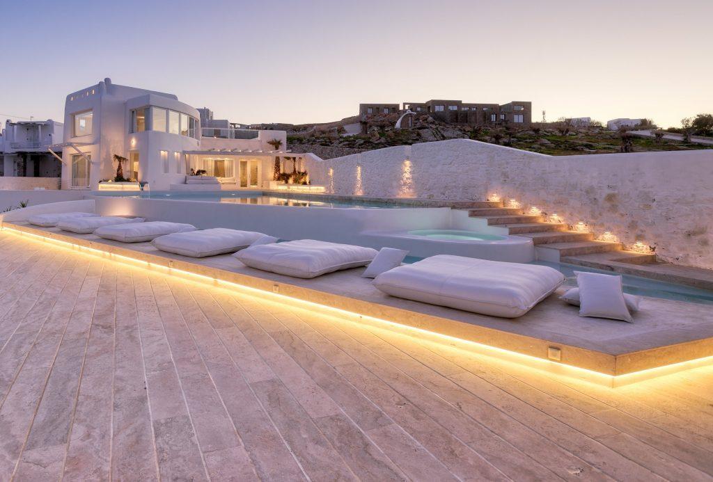 luxury villa with white steps lit by lamps leading to the pool and spacious courtyard