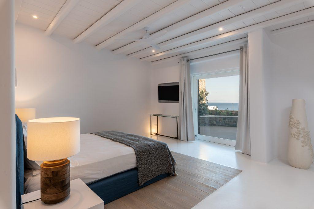 bedroom with large window overlooking the blue sea of ​​Mykonos